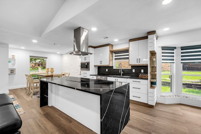 4122 Azalea Ln, Garland, TX 75043 - kitchen with island exhaust hood, a sink, dark countertops, white cabinets, and a kitchen island