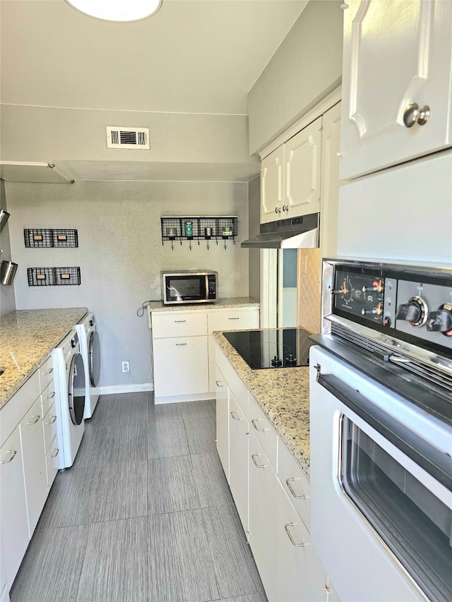 kitchen with wall oven, under cabinet range hood, black electric stovetop, stainless steel microwave, and white cabinets