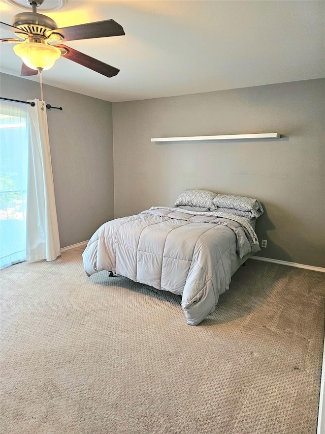 carpeted bedroom featuring baseboards and a ceiling fan