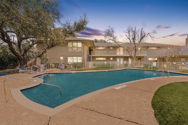 community pool with fence and a patio area