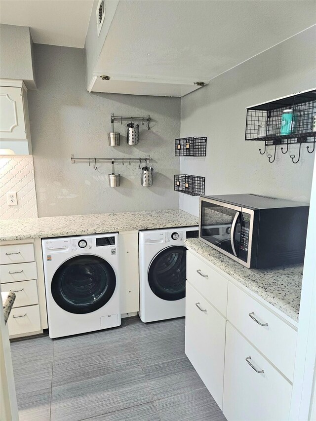 clothes washing area featuring washer and dryer and tile patterned floors