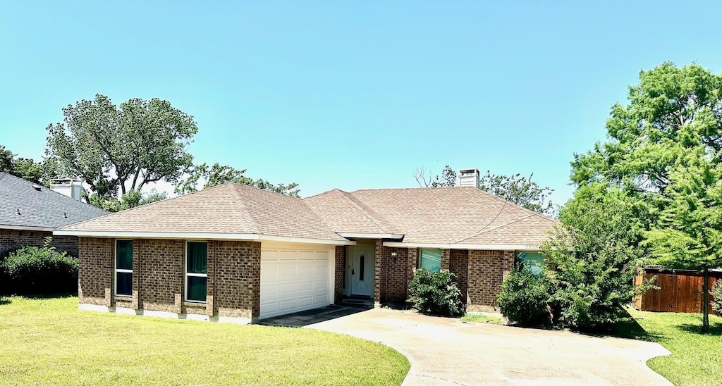 2525 Rosebud Ct, Carrollton, TX 75006 - ranch-style house featuring a garage, concrete driveway, a chimney, brick siding, and a shingled roof