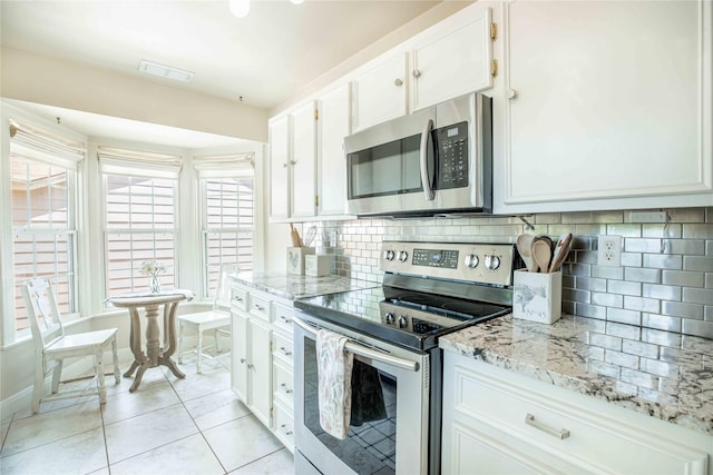 3418 S 11th St, Abilene, TX 79605 - kitchen with appliances with stainless steel finishes, white cabinets, backsplash, and light stone counters