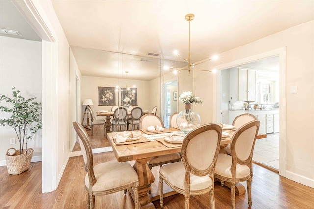 3418 S 11th St, Abilene, TX 79605 - dining area with light wood finished floors, a chandelier, and baseboards