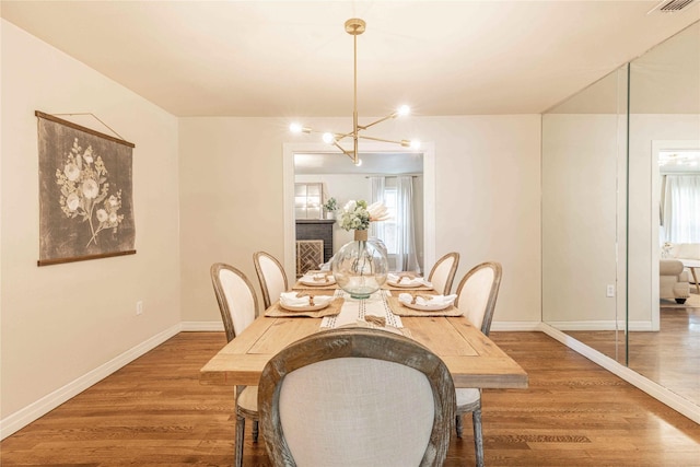 3418 S 11th St, Abilene, TX 79605 - dining room featuring wood finished floors, a chandelier, baseboards, and plenty of natural light