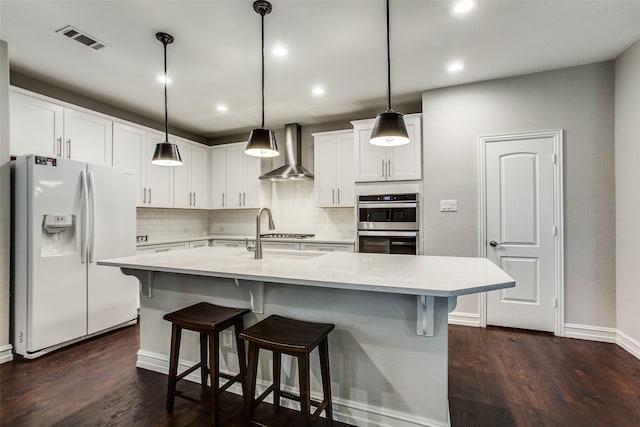 414 Kirkland Rd, Garland, TX 75044 - kitchen with appliances with stainless steel finishes, wall chimney exhaust hood, light countertops, backsplash, and dark wood-style flooring