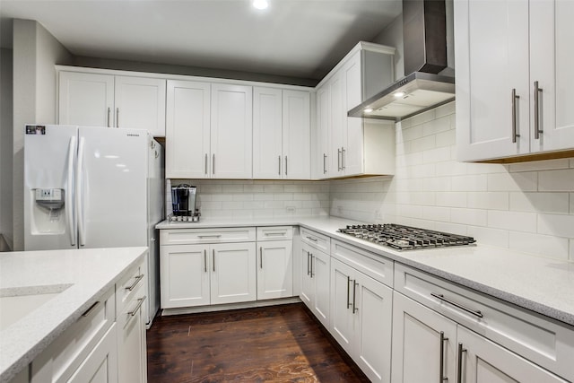 414 Kirkland Rd, Garland, TX 75044 - kitchen featuring wall chimney exhaust hood, stainless steel gas stovetop, white refrigerator with ice dispenser, white cabinetry, and decorative backsplash