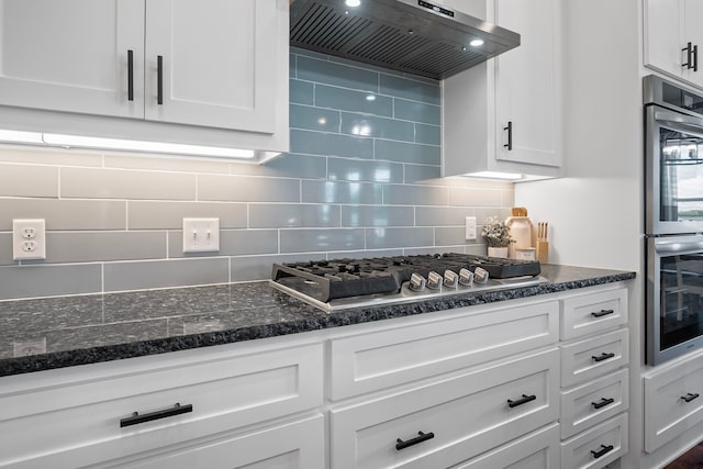 174 Rs County Road 3160, Emory, TX 75440 - kitchen featuring wall chimney exhaust hood, appliances with stainless steel finishes, white cabinetry, decorative backsplash, and dark stone counters