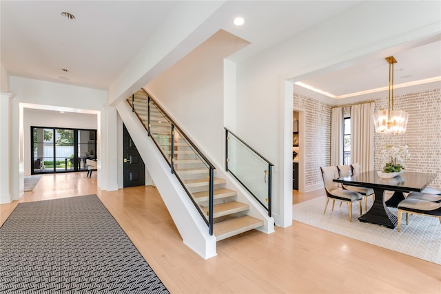 3713 Greenbrier Dr, University Park, TX 75225 - staircase with a chandelier, wood finished floors, brick wall, and recessed lighting