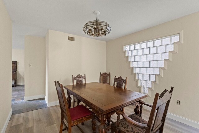 9838 Baseline Dr, Dallas, TX 75243 - dining space with wood finished floors, a chandelier, baseboards, and stairway