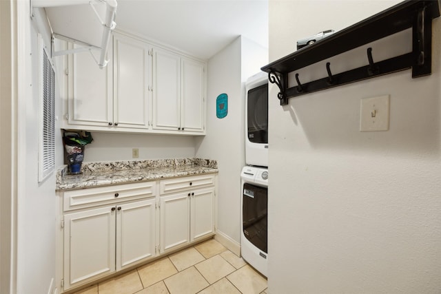 7008 Joyce Way, Dallas, TX 75225 - clothes washing area with estacked washer and dryer, cabinet space, and light tile patterned flooring