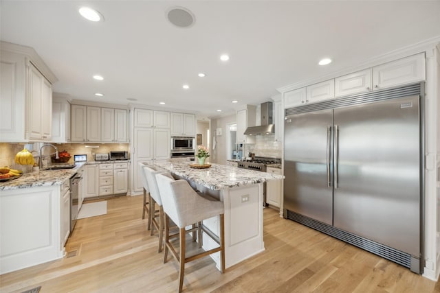 7008 Joyce Way, Dallas, TX 75225 - kitchen featuring built in appliances, wall chimney range hood, a sink, backsplash, and a kitchen island