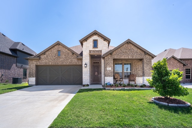513 Lake Cove Dr, Little Elm, TX 75068 - view of front of home with brick siding, stone siding, central AC, and an attached garage