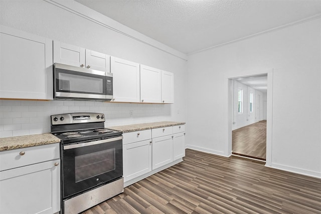 401 E Buffalo St, Forney, TX 75126 - kitchen with stainless steel appliances, dark wood-style flooring, decorative backsplash, white cabinets, and baseboards