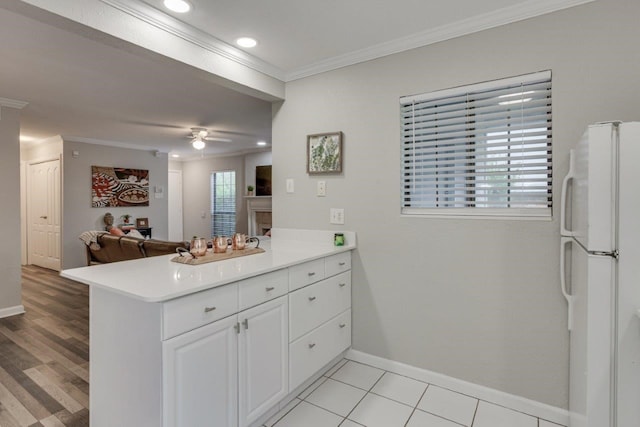 15151 Berry Trl Unit 401, Dallas, TX 75248 - kitchen with freestanding refrigerator, ornamental molding, light countertops, baseboards, and a peninsula