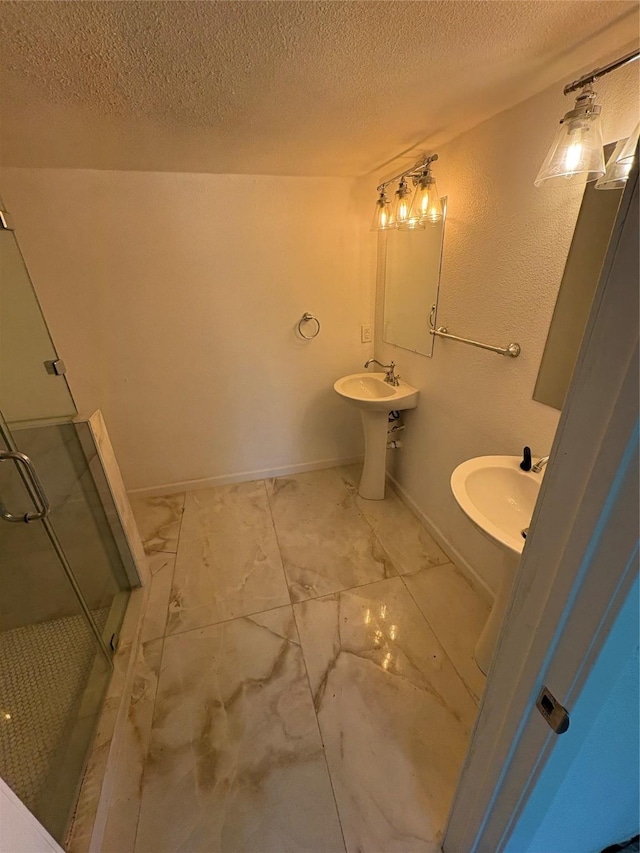401 S Bois D Arc St, Forney, TX 75126 - bathroom with a textured ceiling, a shower stall, a sink, baseboards, and marble look tiles