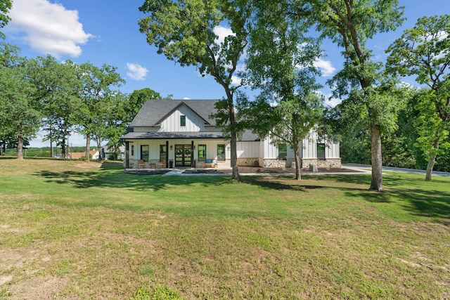 rear view of house featuring a lawn, board and batten siding, and a porch