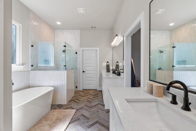 bathroom with a shower stall, a soaking tub, vanity, and recessed lighting