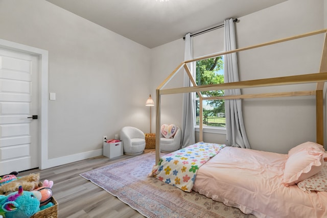 bedroom with wood finished floors and baseboards
