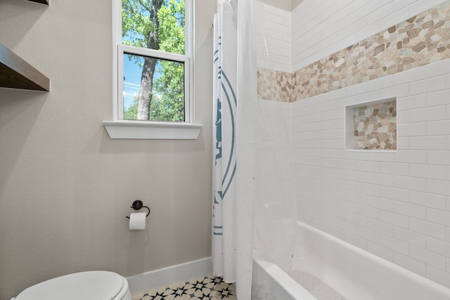 bathroom featuring toilet, shower / bath combination with curtain, and baseboards
