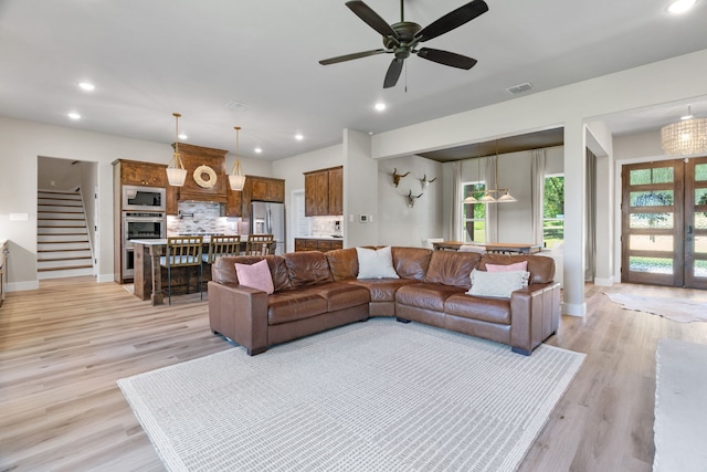 living room featuring stairs, a ceiling fan, baseboards, light wood-type flooring, and recessed lighting