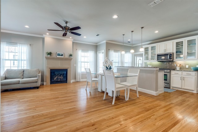 4100 Emerson Ave Unit 8, University Park, TX 75205 - kitchen with appliances with stainless steel finishes, light wood-type flooring, recessed lighting, a kitchen breakfast bar, and white cabinets