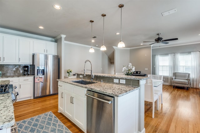 4100 Emerson Ave Unit 8, University Park, TX 75205 - kitchen with stainless steel appliances, a sink, crown molding, an island with sink, and light wood-type flooring