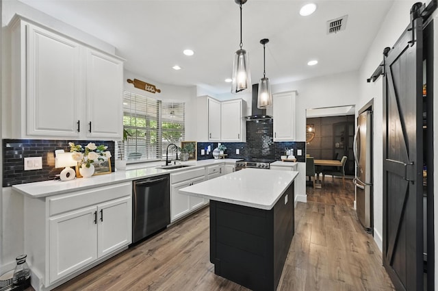 4524 Rosedale Dr, Grand Prairie, TX 75052 - kitchen with appliances with stainless steel finishes, a barn door, a sink, wall chimney exhaust hood, and backsplash