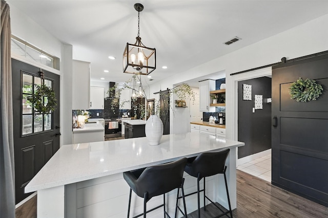 4524 Rosedale Dr, Grand Prairie, TX 75052 - kitchen with a kitchen island, tasteful backsplash, a chandelier, a barn door, and recessed lighting