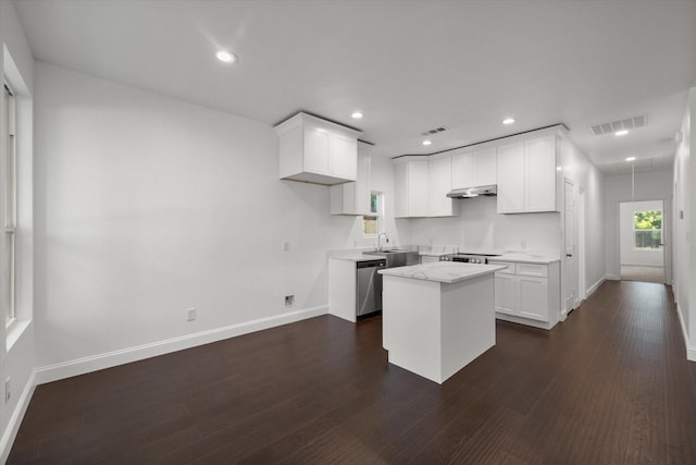 710 E 3rd Ave, Corsicana, TX 75110 - kitchen featuring stainless steel dishwasher, under cabinet range hood, a center island, baseboards, and white cabinetry