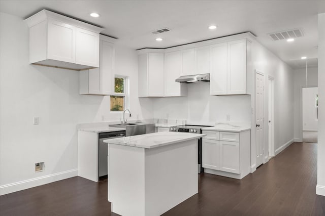 710 E 3rd Ave, Corsicana, TX 75110 - kitchen featuring appliances with stainless steel finishes, a sink, under cabinet range hood, white cabinets, and dark wood-type flooring