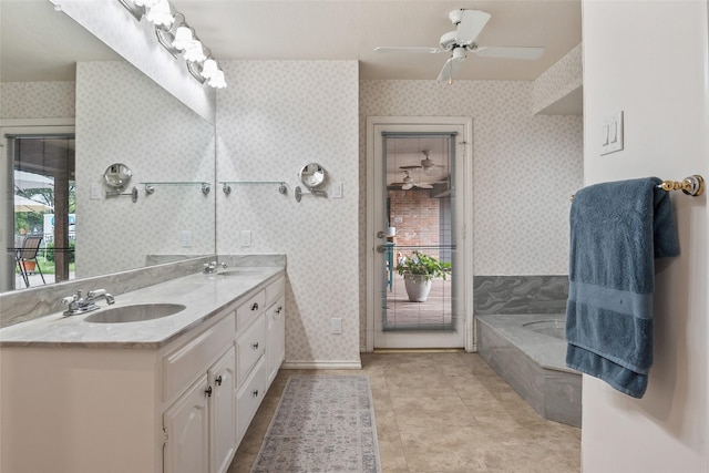 120 Willow Oak Ct, Double Oak, TX 75077 - bathroom with double vanity, a garden tub, ceiling fan, wallpapered walls, and baseboards