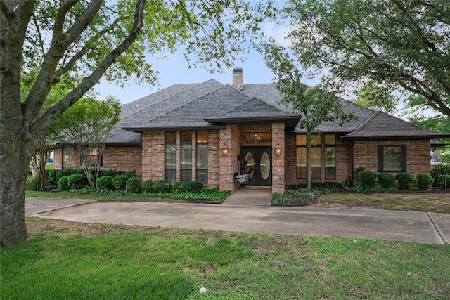 120 Willow Oak Ct, Double Oak, TX 75077 - view of front facade featuring brick siding, a chimney, roof with shingles, and a front yard
