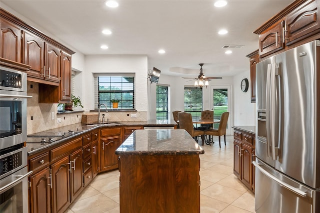 120 Willow Oak Ct, Double Oak, TX 75077 - kitchen featuring stainless steel appliances, a sink, a center island, tasteful backsplash, and healthy amount of natural light