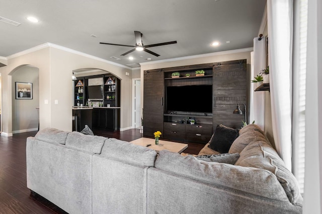 958 Prairie Timber Rd, Burleson, TX 76028 - living room featuring arched walkways, ceiling fan, baseboards, dark wood-type flooring, and ornamental molding