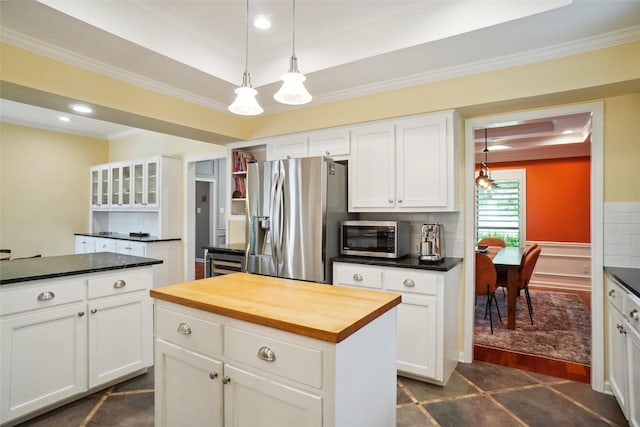 731 Falcon Ln, Coppell, TX 75019 - kitchen featuring stainless steel appliances, butcher block countertops, ornamental molding, a center island, and a tray ceiling