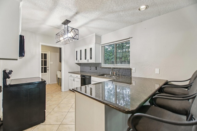611 Buffalo Dr, Arlington, TX 76013 - kitchen with a sink, dishwasher, a peninsula, white cabinetry, and a kitchen bar