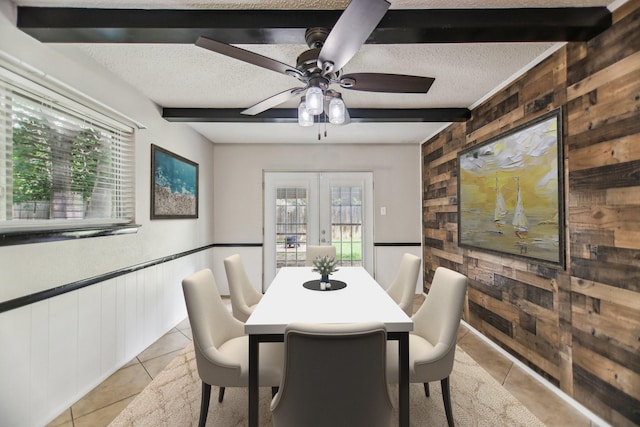 611 Buffalo Dr, Arlington, TX 76013 - dining room featuring wooden walls, light tile patterned floors, french doors, a textured ceiling, and beam ceiling