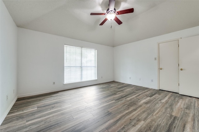1404 Chicota Dr, Plano, TX 75023 - empty room featuring wood finished floors, ceiling fan, vaulted ceiling, and baseboards