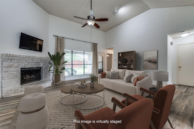 1404 Chicota Dr, Plano, TX 75023 - living room with wood finished floors, a ceiling fan, high vaulted ceiling, and a brick fireplace