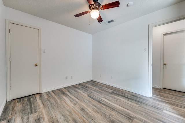1404 Chicota Dr, Plano, TX 75023 - empty room featuring wood finished floors, ceiling fan, a textured ceiling, and baseboards