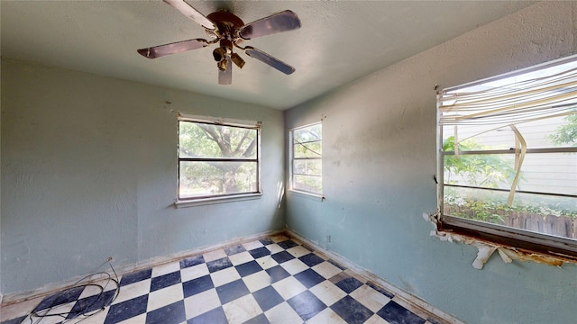 3243 Arizona Ave, Dallas, TX 75216 - spare room with tile patterned floors, a textured wall, ceiling fan, and baseboards