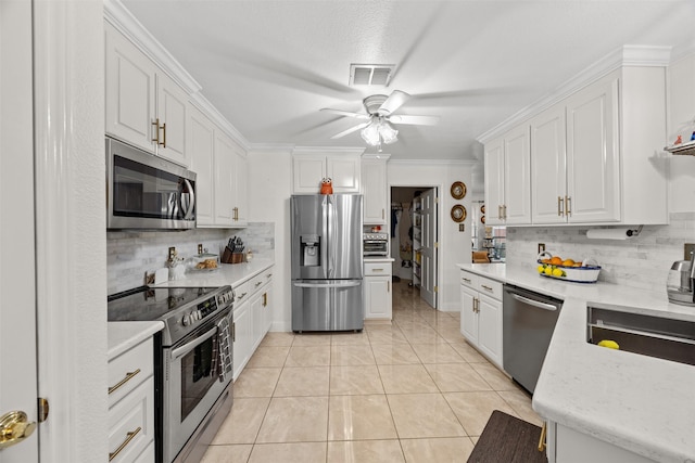 5637 Hunters Bend Ln, Dallas, TX 75249 - kitchen with stainless steel appliances, backsplash, white cabinetry, and crown molding