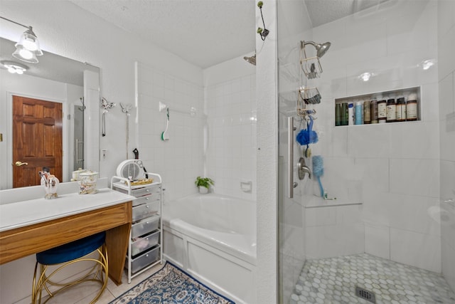 5637 Hunters Bend Ln, Dallas, TX 75249 - bathroom with a shower, a bath, vanity, a textured ceiling, and tile patterned flooring