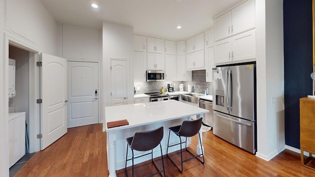 330 Austin Unit 313, Waco, TX 76701 - kitchen with appliances with stainless steel finishes, light wood finished floors, a kitchen breakfast bar, a sink, and recessed lighting