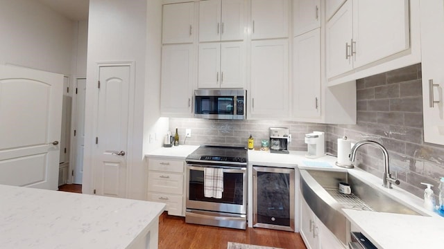 330 Austin Unit 313, Waco, TX 76701 - kitchen featuring stainless steel appliances, wine cooler, a sink, and backsplash