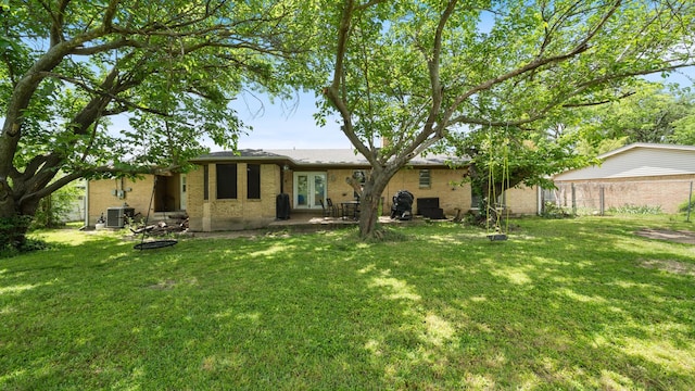 413 E 9th St, Kaufman, TX 75142 - rear view of property featuring brick siding, french doors, central AC unit, and a patio