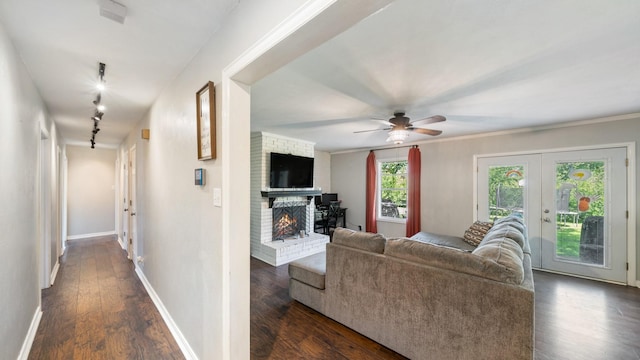 413 E 9th St, Kaufman, TX 75142 - living room featuring dark wood-style flooring, a brick fireplace, a ceiling fan, french doors, and baseboards