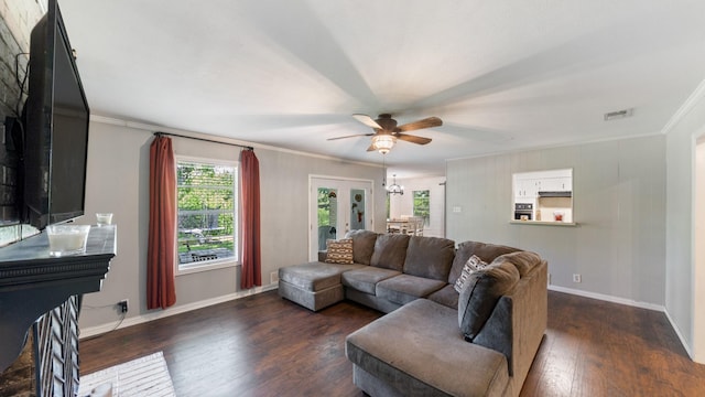 413 E 9th St, Kaufman, TX 75142 - living area featuring a ceiling fan, dark wood-style flooring, crown molding, baseboards, and a chandelier