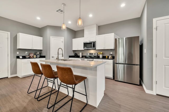 1116 Oakwood Ave, Waco, TX 76706 - kitchen with appliances with stainless steel finishes, a sink, baseboards, a kitchen island with sink, and recessed lighting